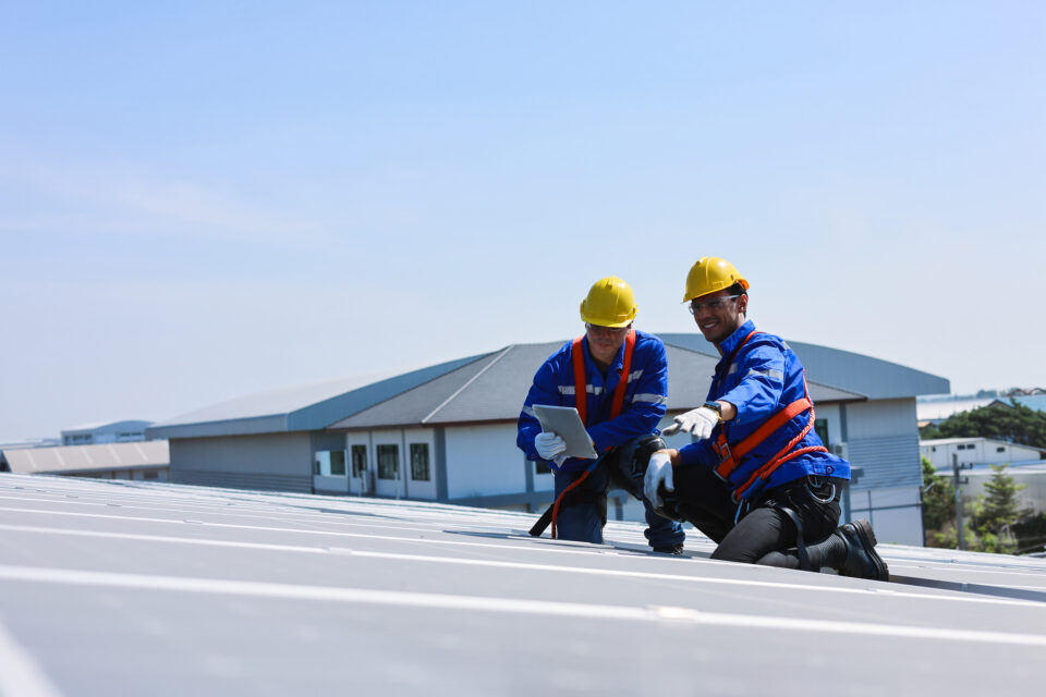 Roofing crew inspecting commercial roof in Alabama for hail damage and assessing repairs after a severe storm.