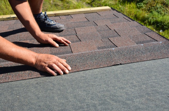 Installing asphalt shingles on a residential roof during a roof replacement project